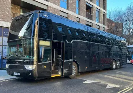 Coach parked by building